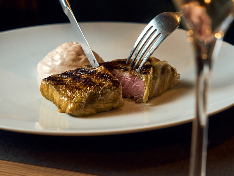 pluma di maialino iberico alla griglia, avvolta nella verza e composta di mandarino, il tutto affumicato con la sua scorza, accompagnata con spuma di castagna